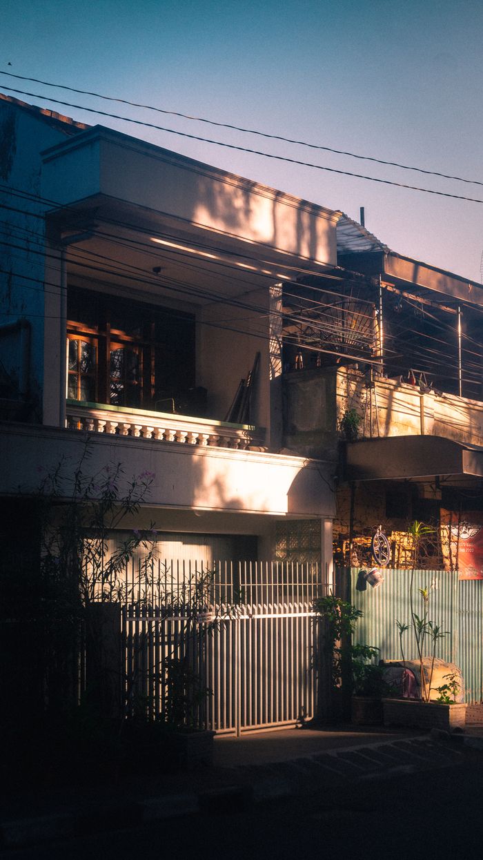 Aesthetic view of an urban home exterior with warm sunlight casting artistic shadows.