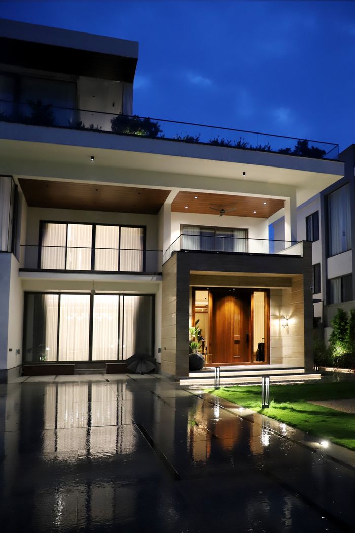 Stunning modern luxury house exterior lit up at night with clean architectural design.