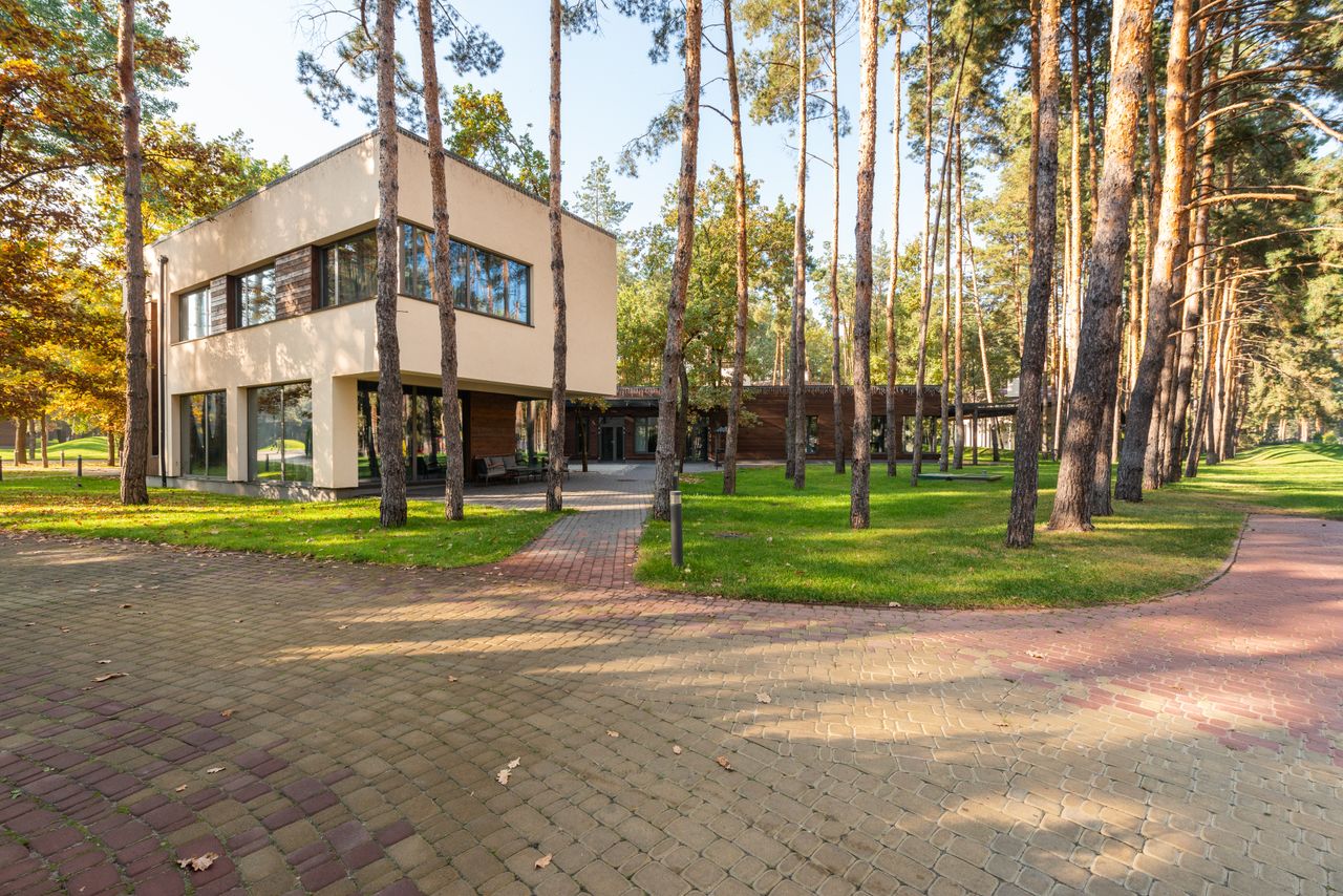 Contemporary house surrounded by tall trees in a forest setting.